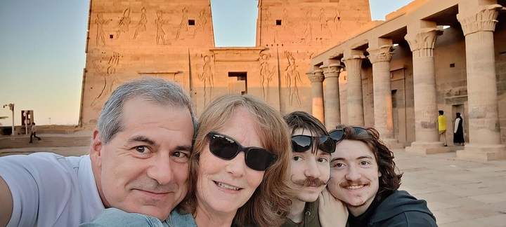 Famille prenant un selfie devant le pylône ensoleillé du temple de Philae, Assouan