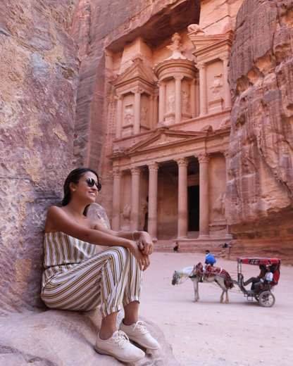 Voyageuse assise sur les rochers devant le Trésor de Pétra, en Jordanie