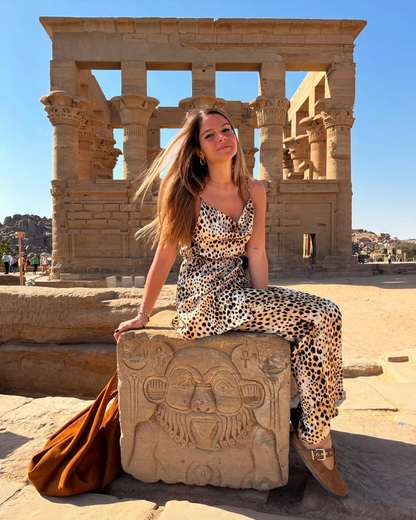 Voyageuse assise sur un bloc sculpté devant le kiosque de Trajan au temple de Philae, Assouan