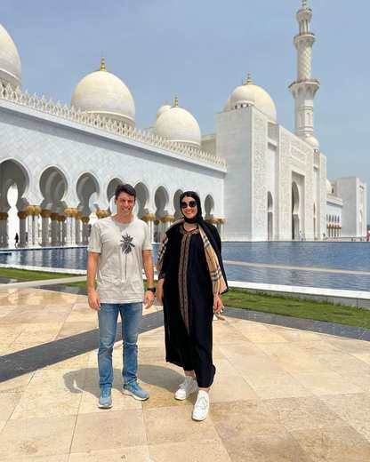 Couple au bord du bassin réfléchissant de la grande mosquée Cheikh Zayed, Abou Dabi